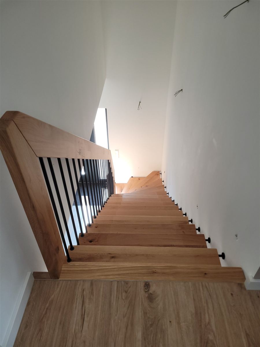 Holztreppe mit schwarzen Streben in einem realisierten Projekt